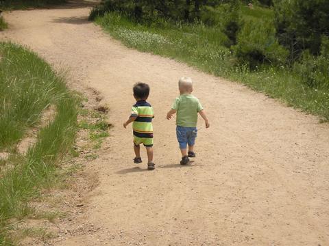 Toddlers walking on dirt road