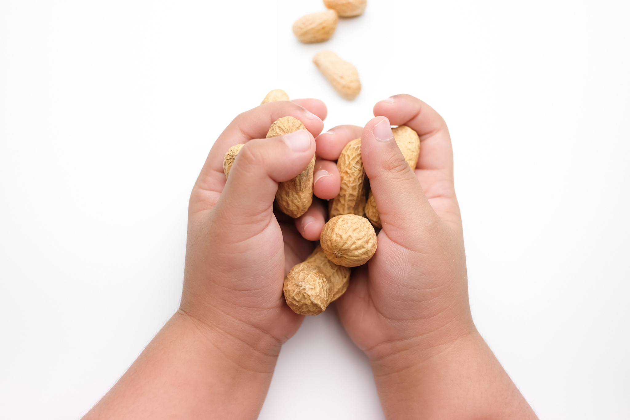 Infant holding peanuts